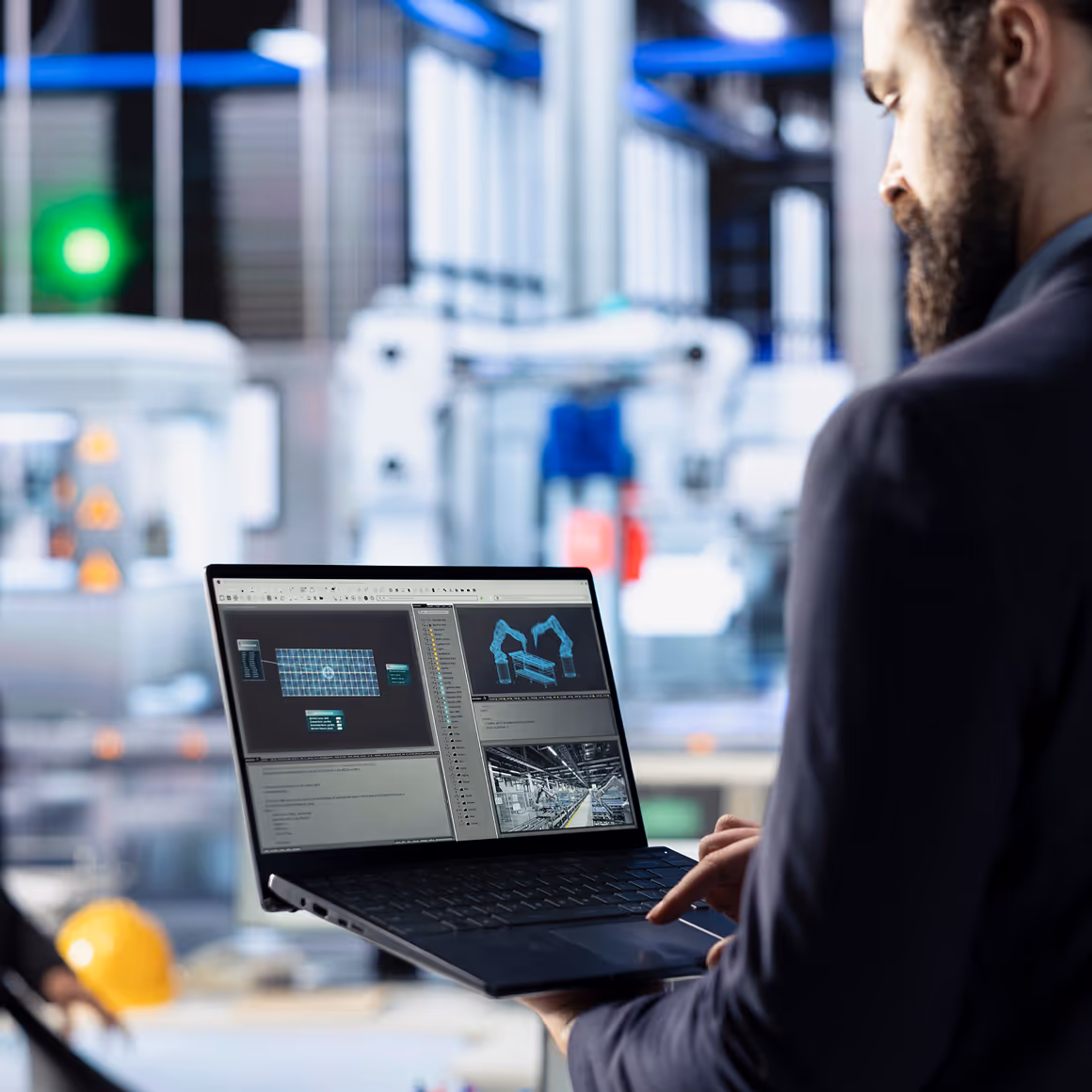 Man using laptop showing factory automation software with robotic arms and manufacturing images.