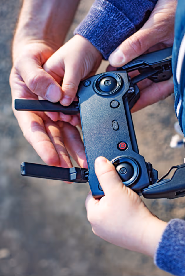 Two people adjusting a remote control used as a stand-in for complex field equipment reviews.